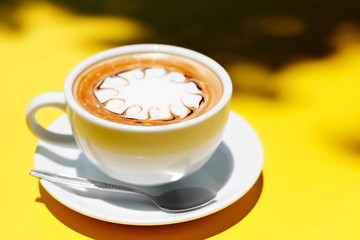 Coffee cup of hot latte art on Yellow background.
