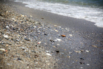 Sea tide. Shore with stone coating. Wave at sea. Background and texture.