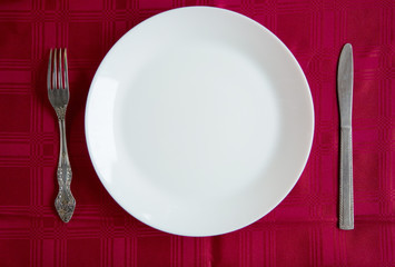 White clean plate and cutlery on the table.