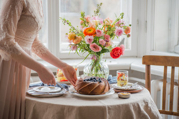 Tea time, Woman hands holding tea pot, flowers and cake