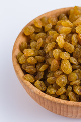 golden raisins on a white acrylic background