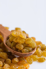 golden raisins on a white acrylic background