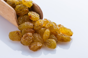 golden raisins on a white acrylic background