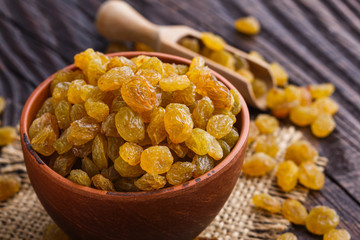 golden raisins on a wooden rustic background