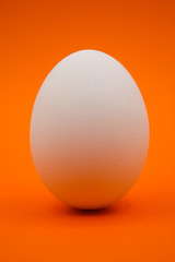 Uovo bianco con sfondo arancio.