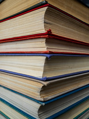 Heap of books of different flowers. The old books put on a table. The turned yellow pages of textbooks