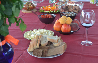 Treats on a table covered with a tablecloth on a summer terrace. Dinner in the open air. Ready to receive guests.