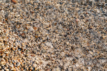 Close up under water beach stones on the seashore. Summer sunrise on coast, Corfu island, Greece. Beach Ionian sea. Wallpaper