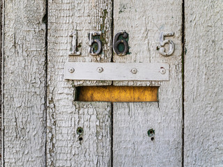Old mailbox on a gray wooden fence
