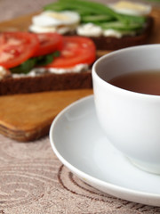 sandwiches with cottage cheese sour cream cheese greens vegetables and a Cup of tea with rose hips