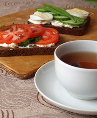 sandwiches with cottage cheese sour cream cheese greens vegetables and a Cup of tea with rose hips