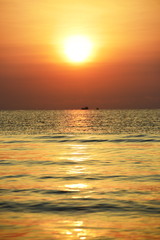 Fototapeta premium The rising sun view and the beach. Beautiful golden yellow sky and sun
