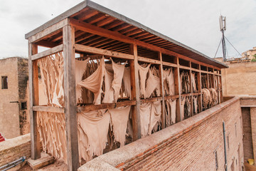 View inside of old medina in Fes, a traditional and old tannery with workers working making methods...
