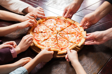 children eat pizza in a restaurant.