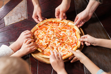 children eat pizza in a restaurant.