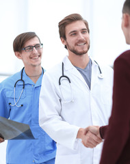 Fototapeta premium smiling doctor shaking hand of a patient