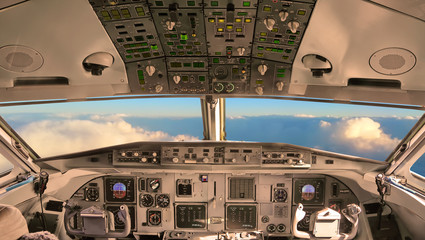 Cockpit of the airplane with sunset sky view through a windshield 