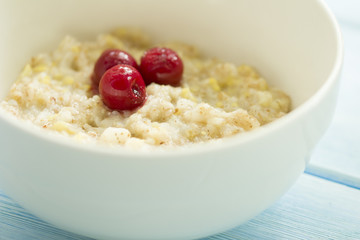 Tasty fresh breakfast . Oatmeal with frozen cherry .  tasty and healthy breakfast concept