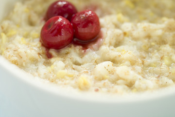 Tasty fresh breakfast . Oatmeal with frozen cherry .  tasty and healthy breakfast concept