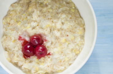 Tasty fresh breakfast . Oatmeal with frozen cherry .  tasty and healthy breakfast concept