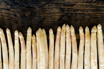 fresh organic white asparagus on an old rustic brown wooden table