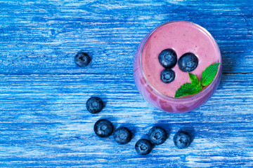 blueberry and blackberry smoothie on blue wooden background. milkshake with fresh blueberries and blackberries . fruit smoothie with ingredients. well being and weight loss concept. top view