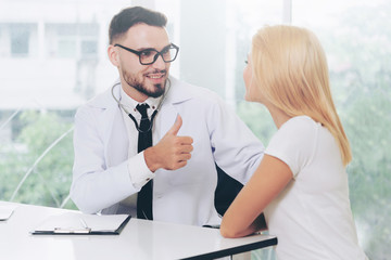 Male doctor is talking with female patient in hospital office. Healthcare and medical service.