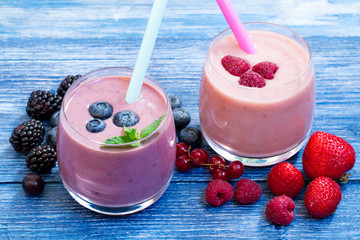 Homemade smoothie with fresh blueberries and strawberry on rustic blue background. weight loss concept. blueberry smoothie on blue wooden table. milkshake with fresh berries. berry jogurt smoothie.