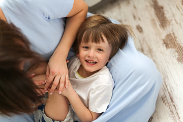 boy is blond in the arms of his mother, a big hug, close up