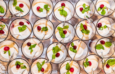 Yogurt with cranberry and basil, served in a glass. Food concept background.