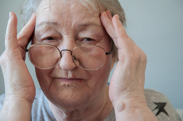 Elderly woman with beautiful face in wrinkles with gray hair with glasses. Closeup portrait. Grandmother Retired waiting for social assistance.