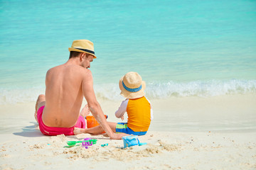 Toddler boy on beach with father
