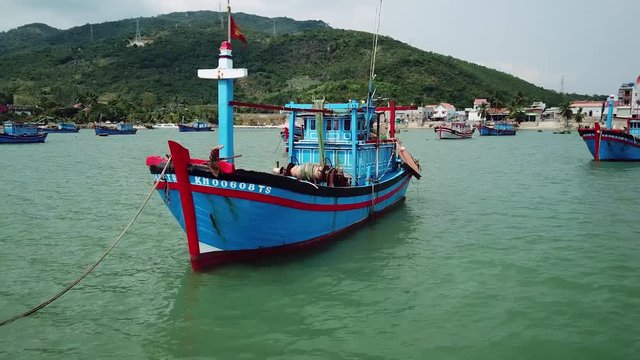 Aerial around fishing boats ships traditional stands sea bay. Labor profession fishermen catch. Old authentic village. Beautiful natural exotic landscape mountains. Exotic Vietnam China Asia