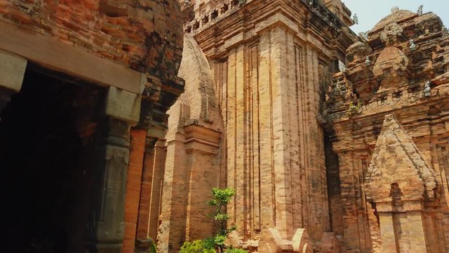 Gimbal close up stone red entrance orange old temple Vietnam Nha Trang ruin nobody. Authentic culture Asia. Unusual landmark heritage ancient unique architecture. Sunny day. Travel tourism. Dolly