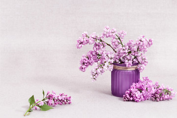 Spring flowers of lilac in vase on rustic tablecloth with copy space. Lilac closeup. Selective focus.