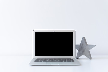 Open laptop and concrete grey star on the desk with white background