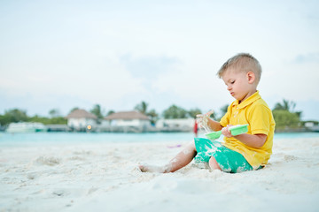 Three year old toddler playing on beach