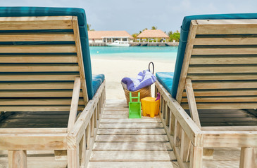 Tropical beach with loungers and palm trees
