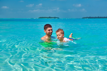 Toddler boy learns to swim with father
