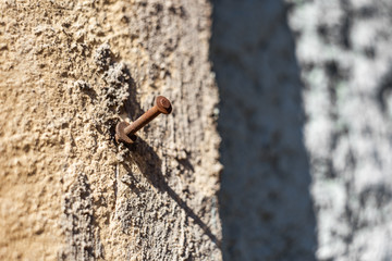 Rusty bolt screwed into a old stone wall