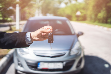 Hand of business man gives the car key