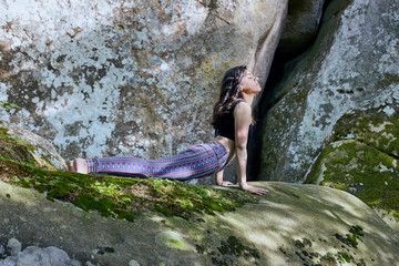 Young girl in mountains doing yoga exercise outdoor.