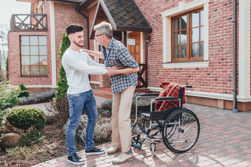 Seniot man gets up on wheelchair and his son helping him !