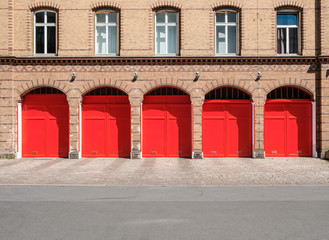 fire department builidng facade with red doors and empty street -