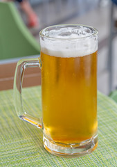 Glass of light beer on a dark pub