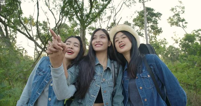 SLOW MOTION - Group of young asian girls on hiking adventure in countryside. Hiker camping in woods. Travel and friendship Concept.