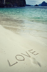 Love and romance. The inscription on the sand. Holidays by the sea.