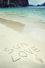 Love and romance. The inscription on the sand. Holidays by the sea.