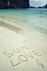 Love and romance. The inscription on the sand. Holidays by the sea.
