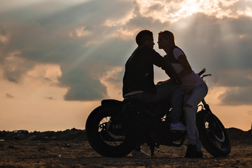 Fototapeta na wymiar Couple on a motorbike at sunset